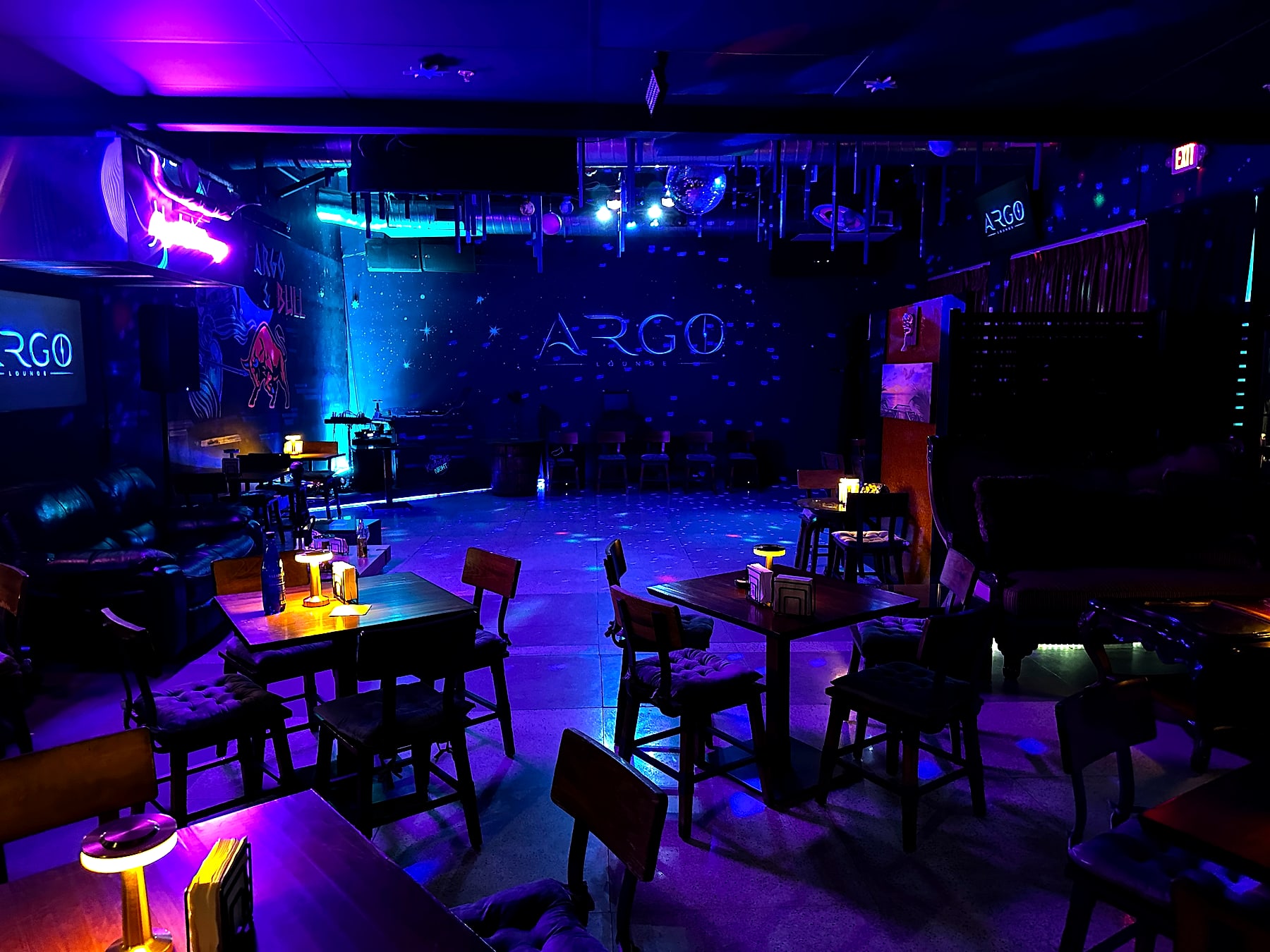 The Argo Lounge main room glowing in blue and purple with the Argo ship and bull murals